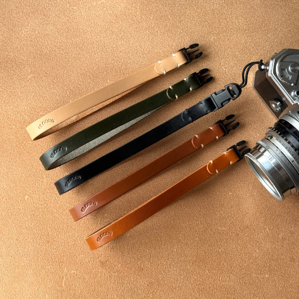 Set of camera straps from GLOODS in various colors on a beige surface 