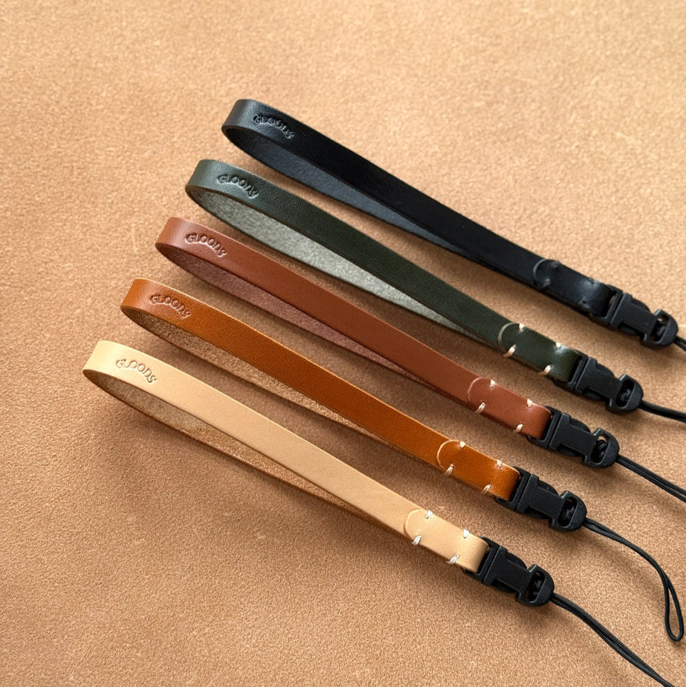 Set of leather wrist straps for cameras from GLOODS in various colors on a beige background